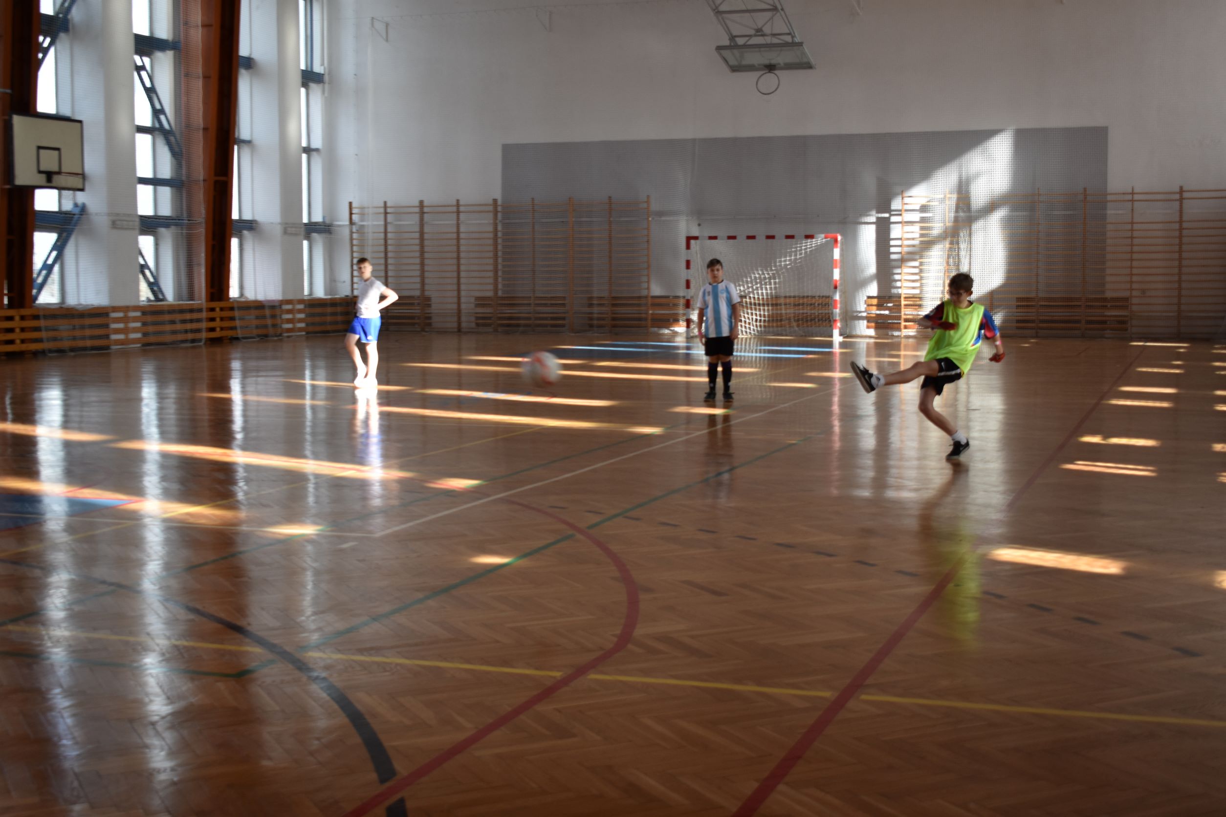 Chłopcy grający w piłkę nożną na hali sportowej 