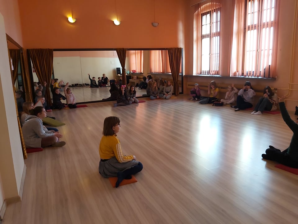 zajęcia dla dzieci w sali lustrzanej, dzieci siedzą na ziemi w kole