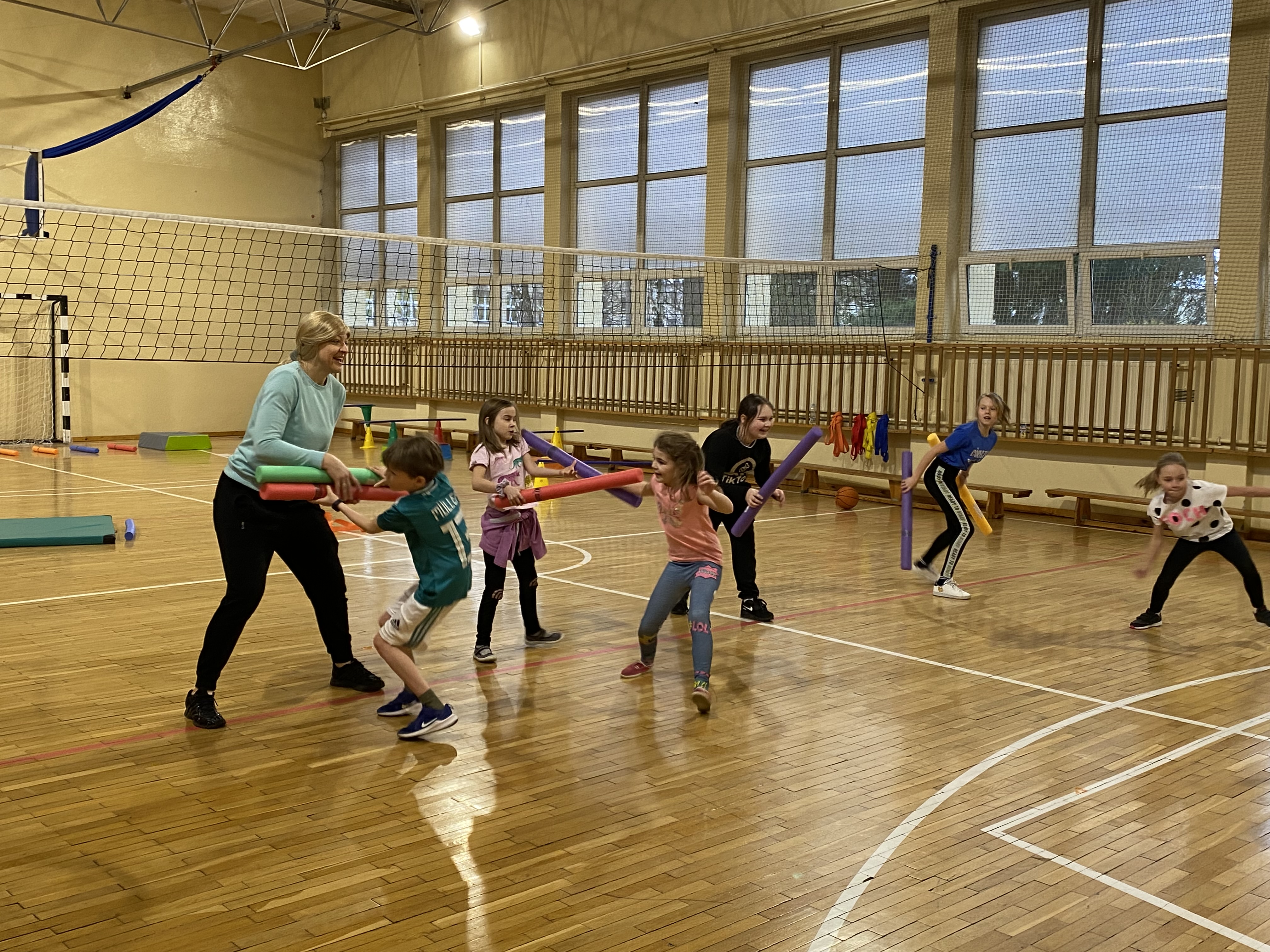 Dzieci podczas zabawy z "makaronami" na sali gimnastycznej