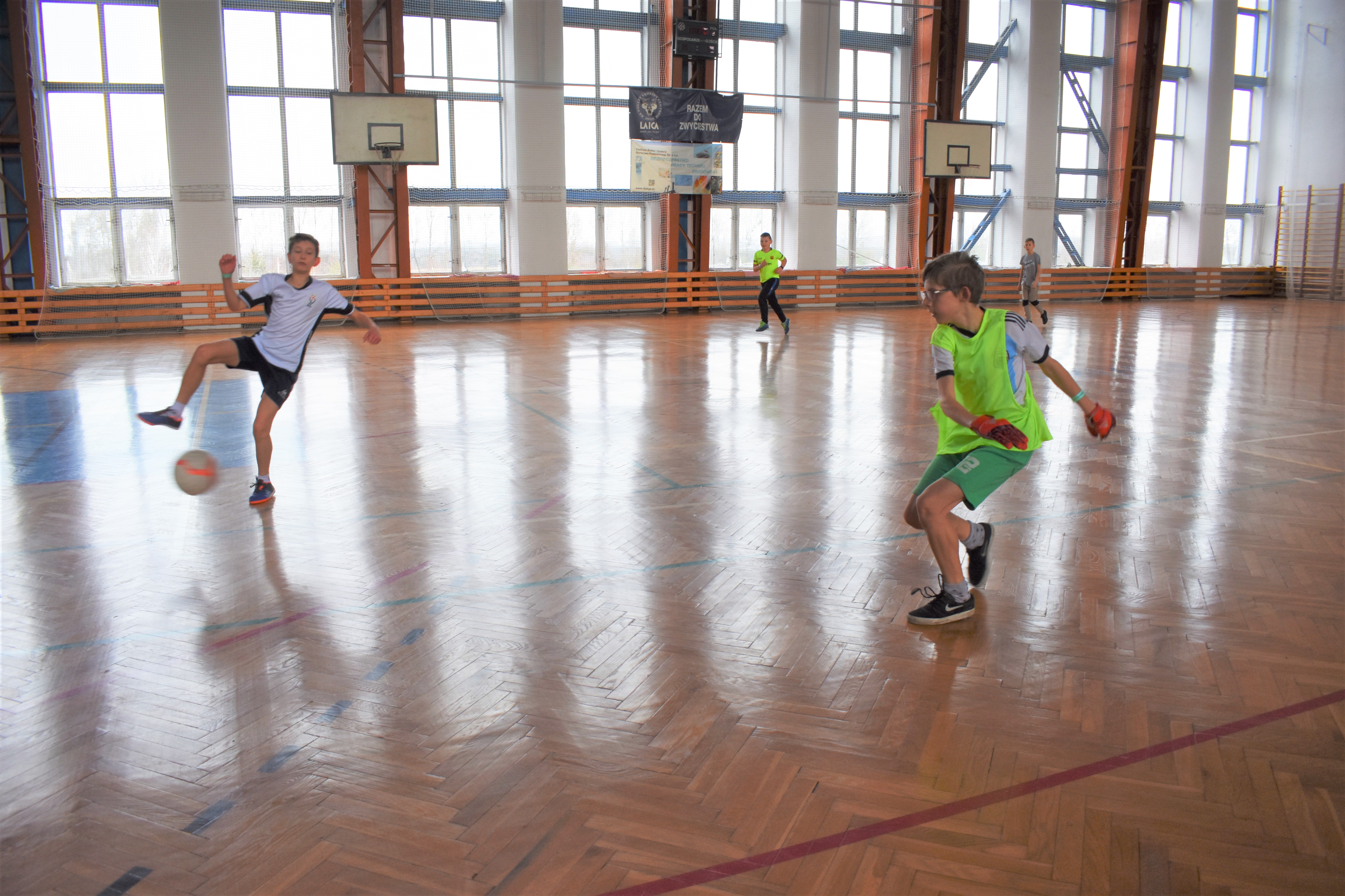 Chłopcy podczas meczu piłki nożnej na hali sportowej