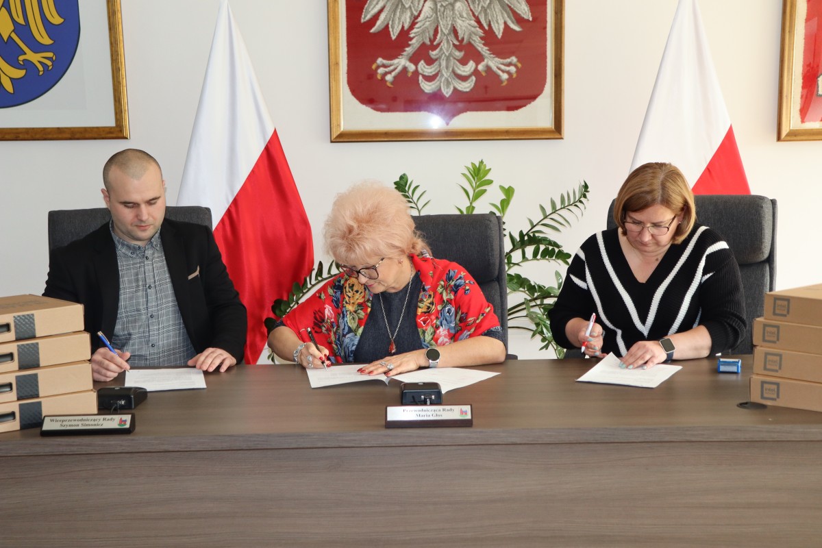 Na zdjęciu trzy osoby podczas podpisania dokumentów
