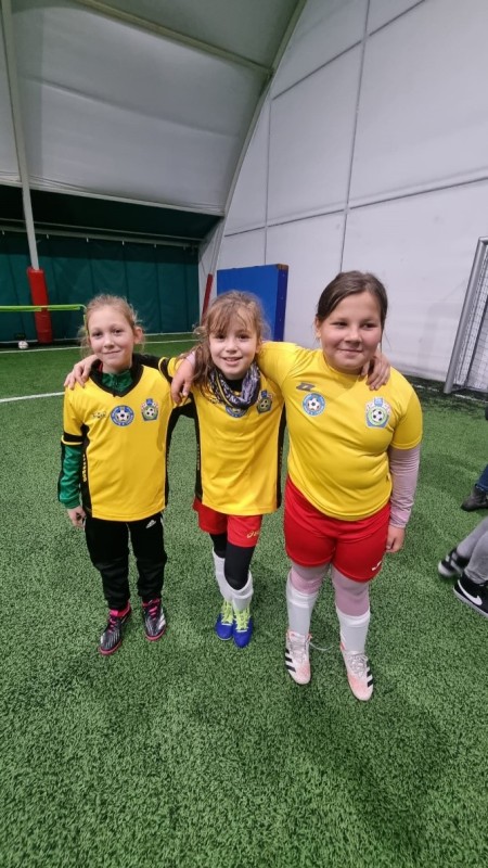 Trzy dziewczynki w strojach piłkarskich 